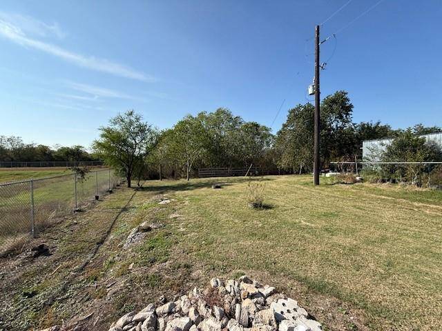 The lot for sale begins at the treeline and is a wooded area.