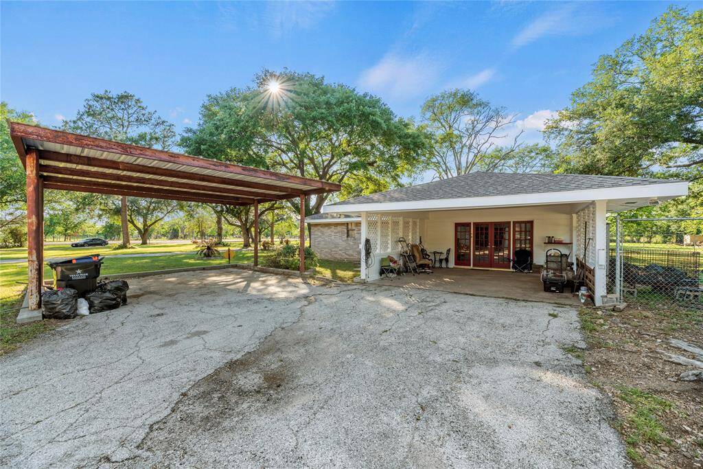 Side area of home has 2 carport areas and a converted garage with french doors as the access point.