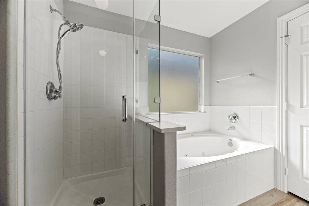 The oversized walk-in shower, adorned with stunning tile work and a sleek glass front, offers a luxurious escape for a quick rinse or a refreshing retreat.
