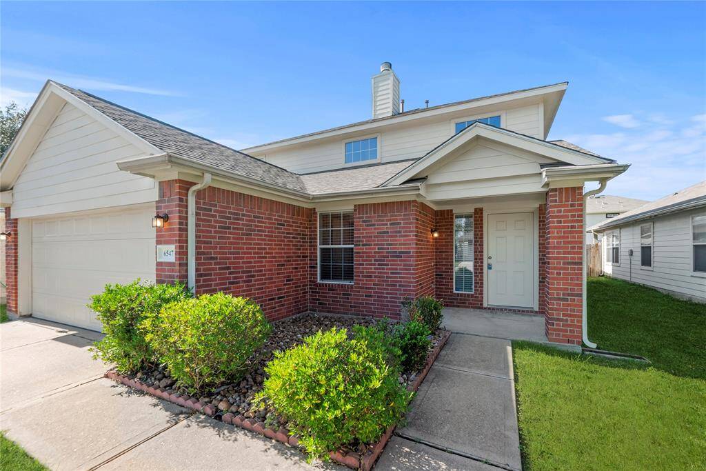 The combination of a professionally landscaped pathway and transom window framing the front door creates a welcoming entrance.