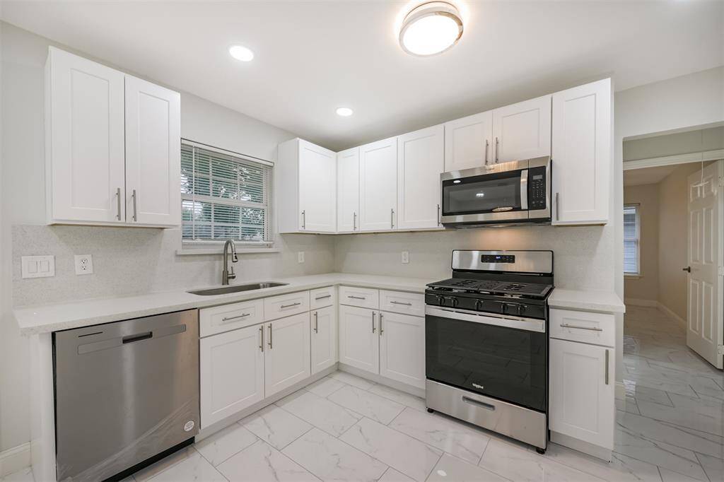 This beautifully updated kitchen features sleek cabinetry, elegant tile backsplash, and plenty of counter space for your culinary creations.