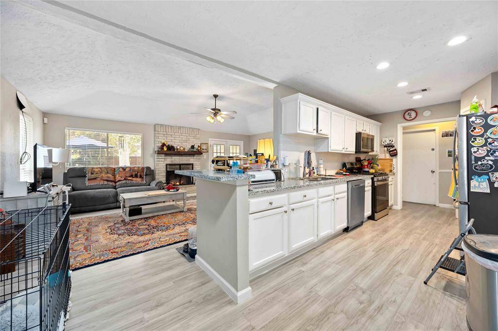 Kitchen features SS appliances, gas range and granite countertops.