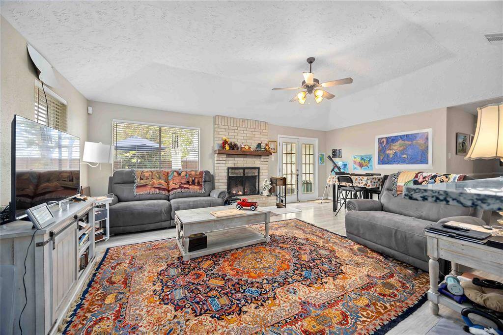Family Room with cozy fireplace, vaulted ceiling, french doors leading to the patio and a ton of natural light.