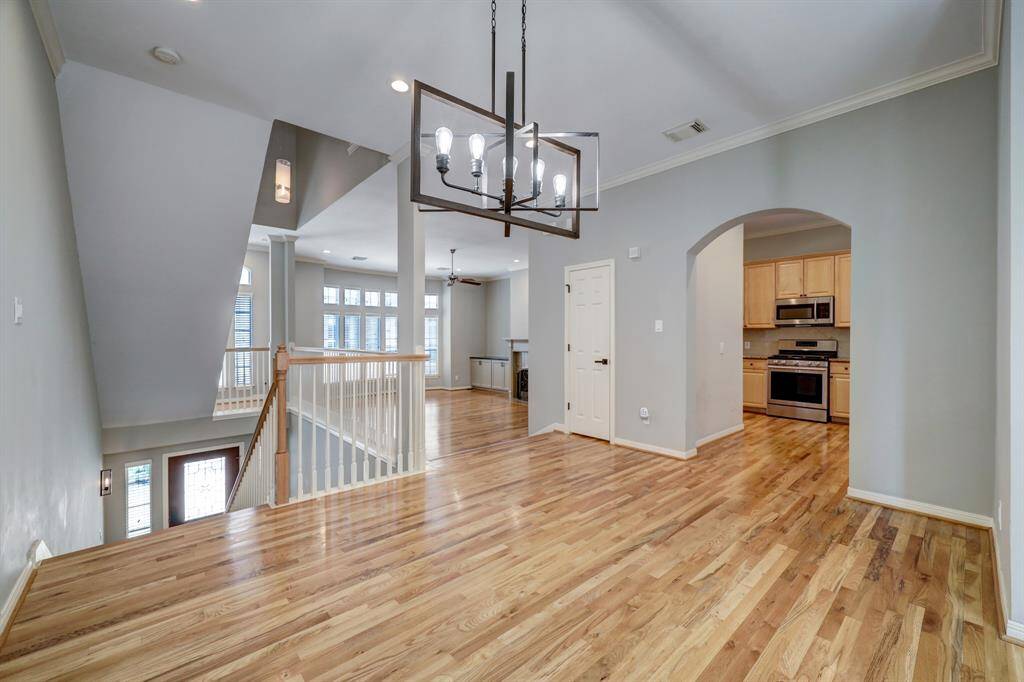 [Formal dining] Contemporary modern chandelier, and gleaming hardwoods. Located on the second floor with a view of the living room and kitchen