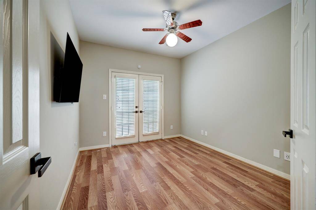 [Secondary bedroom] located on the first floor with private access to patio, mounted TV included in lease