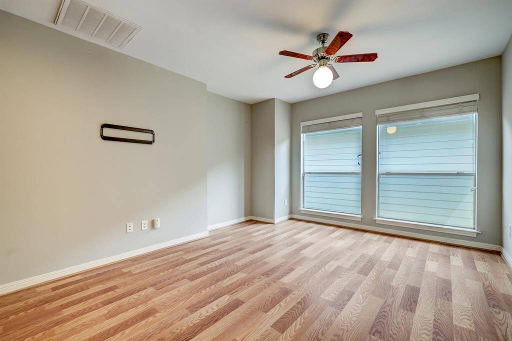 [Secondary bedroom] Located on the first level. Neutral paint, beautiful floors and ceiling fan