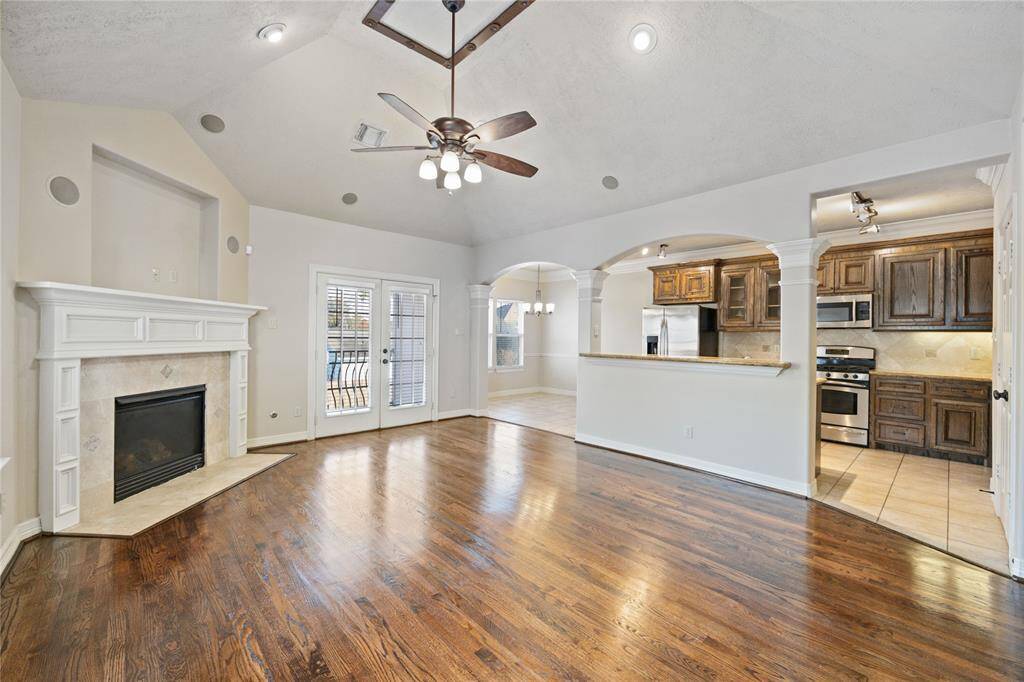 This charming two-story home features a stone facade and a welcoming balcony, with a spacious two-car garage. It's nestled in a serene gated community with backyard space.