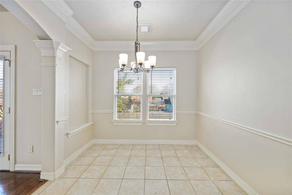 This kitchen features elegant wooden cabinetry, granite countertops, and stainless steel appliances, including a gas stove and dishwasher. It boasts a functional layout with ample storage and a double sink, perfect for modern living.