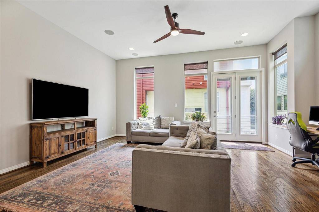 Spacious living area with door to second floor balcony.