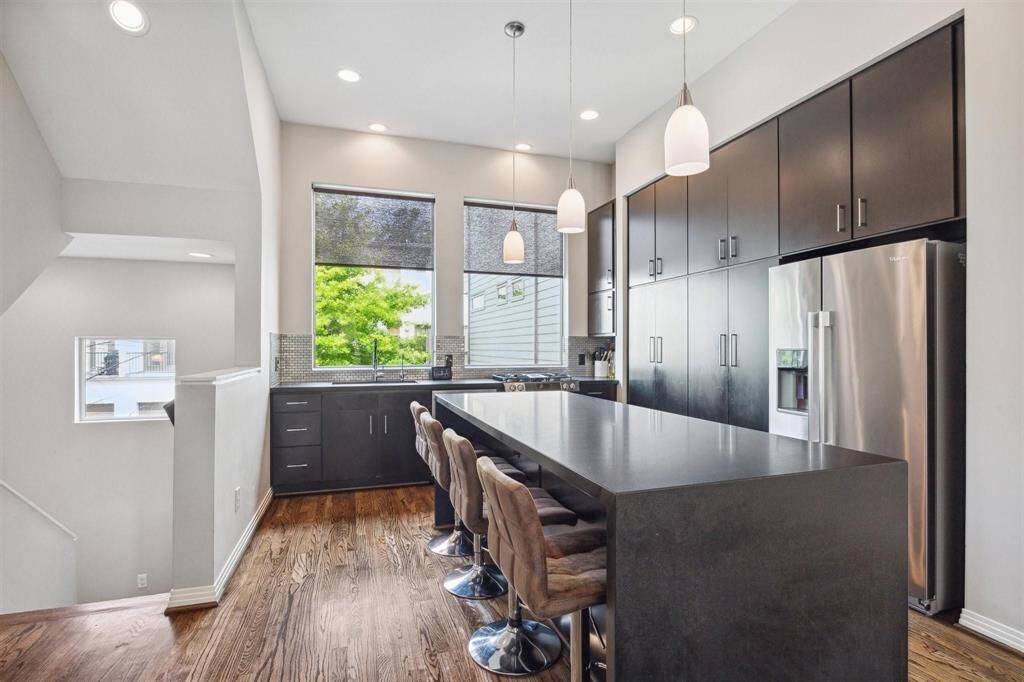 Beautiful natural light kitchen.  Large granite waterfall island.  Seller to leave the 4 bar stools if Buyer desires.   REFRIGERATOR INCLUDED.