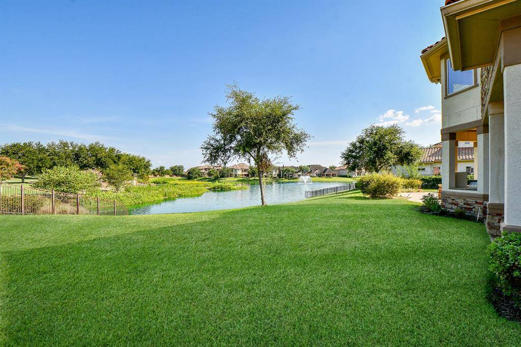This home offers a spacious backyard with a serene water view, manicured lawn, and direct access to a community pond, perfect for enjoying the outdoors and entertaining.