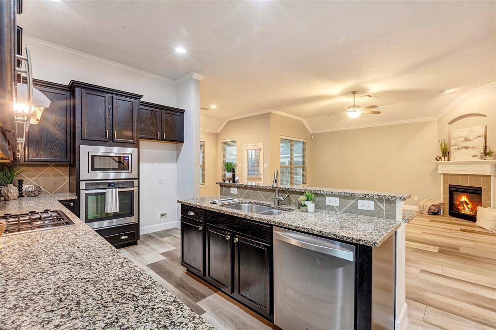 A chef’s delight, the kitchen features a gas cooktop, stainless steel appliances, and so much prep space.