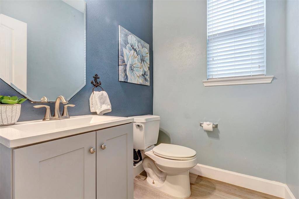 Down the hall, near the home office and front entry, is this large half bath. Not pictured, but just outside the door, is a large storage closet and installed coat rack. All features are perfect for residents and first-floor visitors!