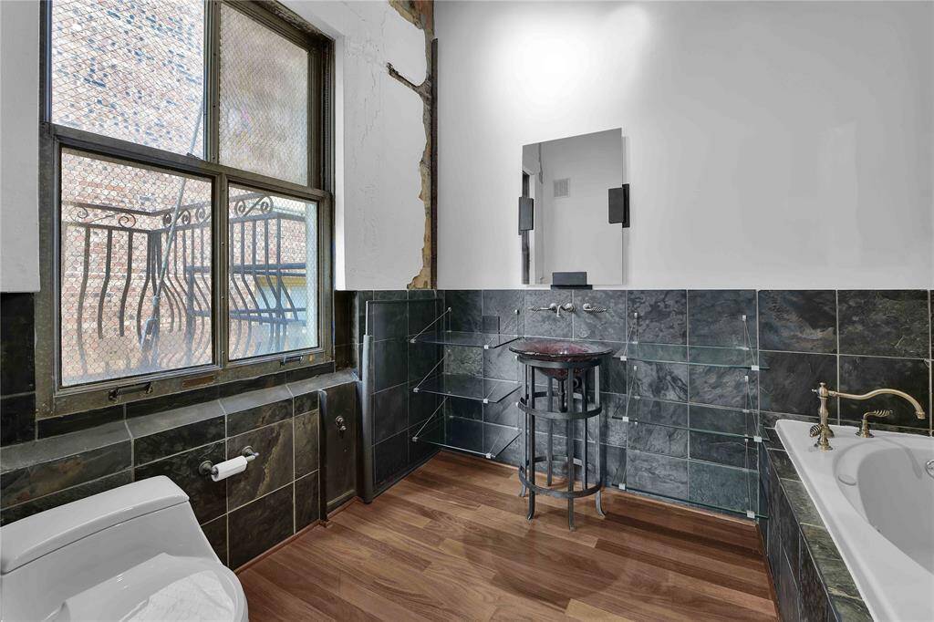 Primary Bath room with oversized shower, Jetted tub and metal and art glass pedestal sink with unique glass shelves