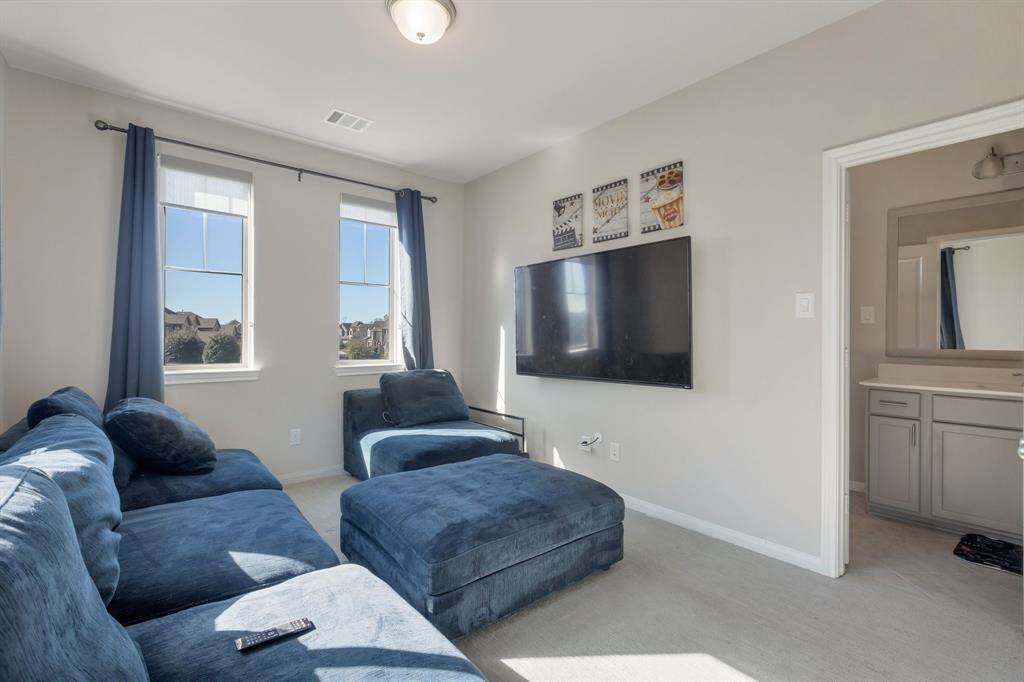 Secondary bedroom is being used as a theater room. The full bath in the background adjoins with another secondary bedroom as well. Black out curtains will stay with the home.