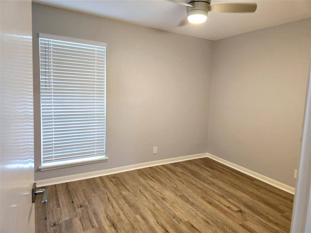 The second bedroom features a new large window that allows natural light to flood this space.  New blinds, new floors, new ceiling fan w/light fixture.