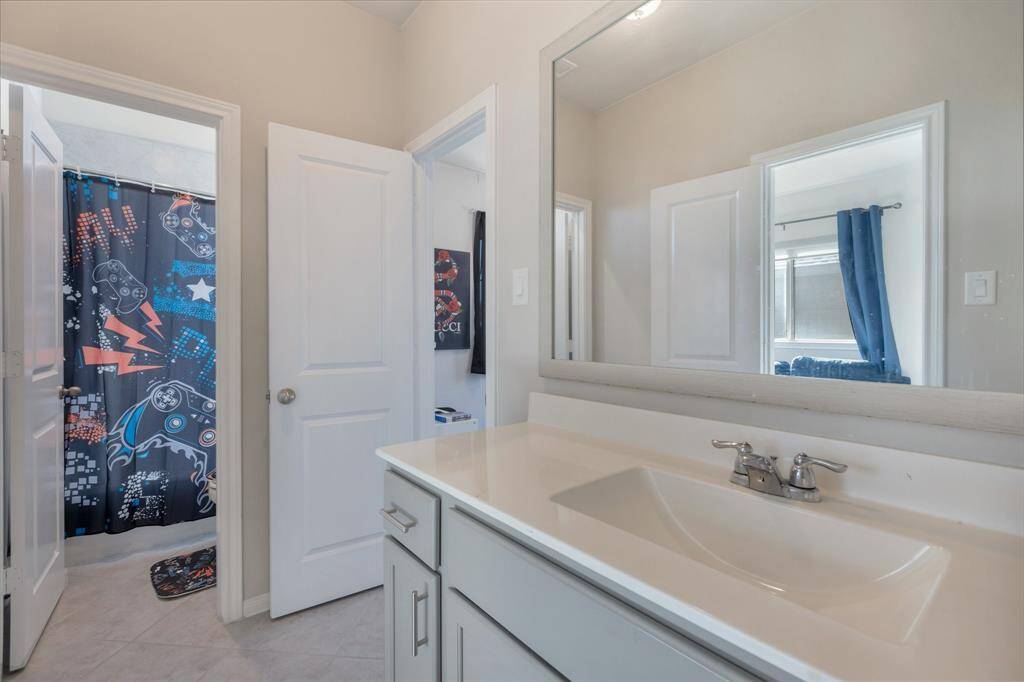 Full bath is shared by the secondary's with a separate bath/shower area. Notice the framed mirror as well.