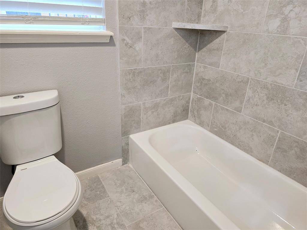The second bathroom includes a separate new toilet, a tub/shower combo, and a new window that floods the area with natural light.