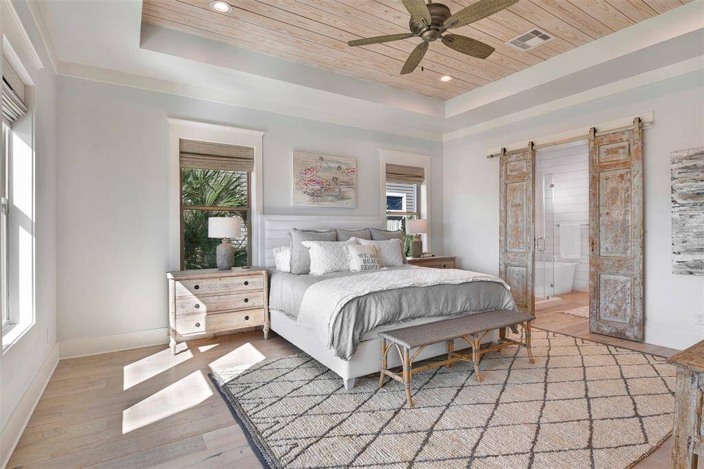 Spacious primary suite featuring wood plank ceiling...check out the custom barn doors on the primary bathroom
