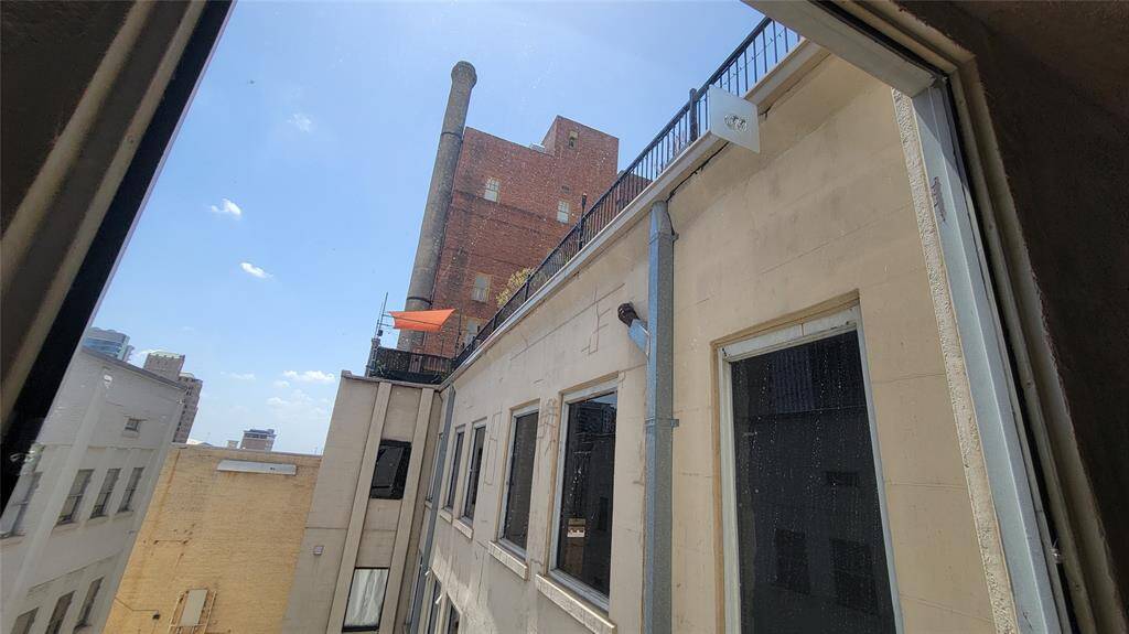 Entrance window view of 10th floor unit with roof top terrace railing.