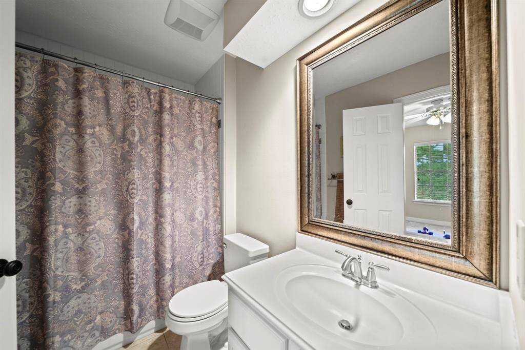 Hollywood style bathroom with shower/tub combo, attached to a secondary bedroom and easy access to the game room.
