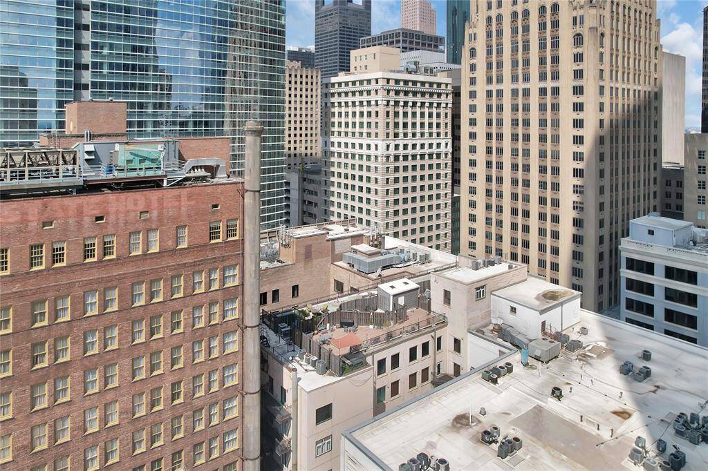 Arial view of building roof and private rooftop terrace with surrounding buildings in downtown Houston.