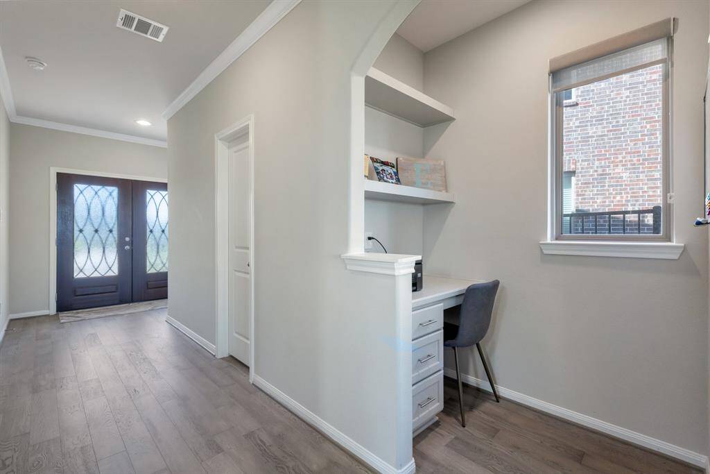 Beautiful solid wood double doors with wrought iron work as you enter the house. The half bath and the office cubby are shown here as well.