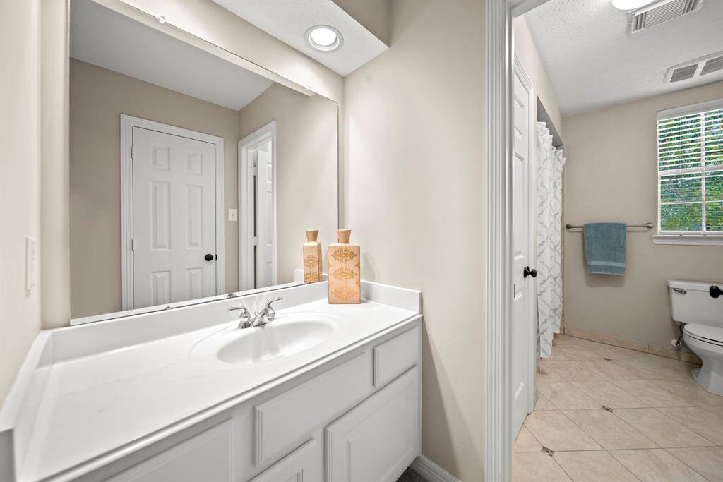 Jack & Jill bathroom features updated tile flooring, recessed lighting, separate vanities and a shower/tub combo.