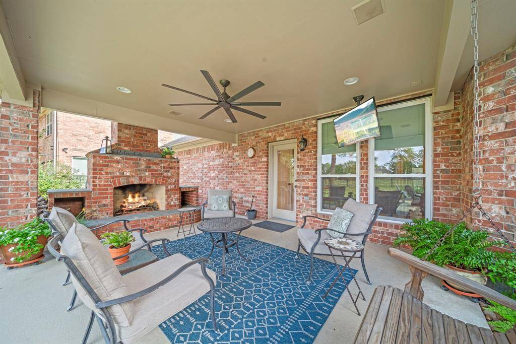 Cozy up around the brick and stone fireplace (equipped with a gas line and log lighter for added convenience!), watch the game or relax on the swing!
