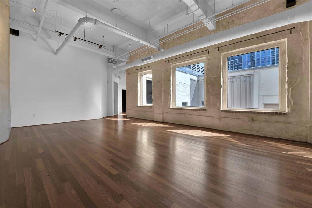 Main Living area showing exposed duct work, support beams and overall loft space design from original building.