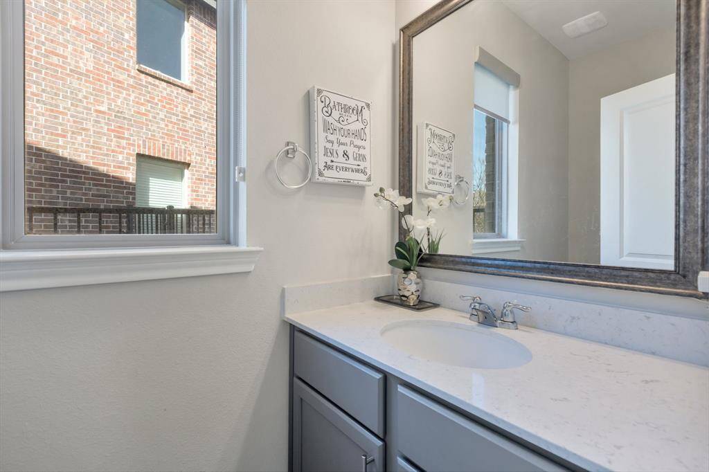 Half bath has matching countertops to the kitchen as well as a beautiful framed mirror.