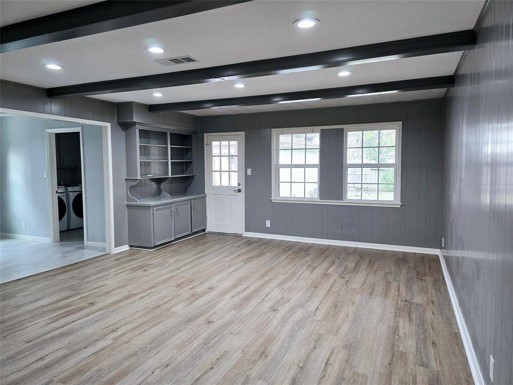 From the family room, you can access the covered patio/deck to enjoy a morning or afternoon tea. Large windows flood this area with natural light. The gray walls, and exposed ceiling beams add to the contemporary look.