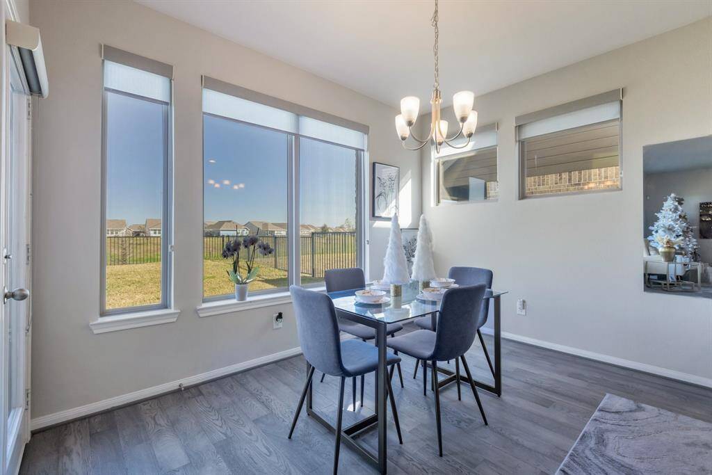 View through the wall of windows with Roman shades from the breakfast room. Home is light and bright. Door to the patio and yard is here on the left.