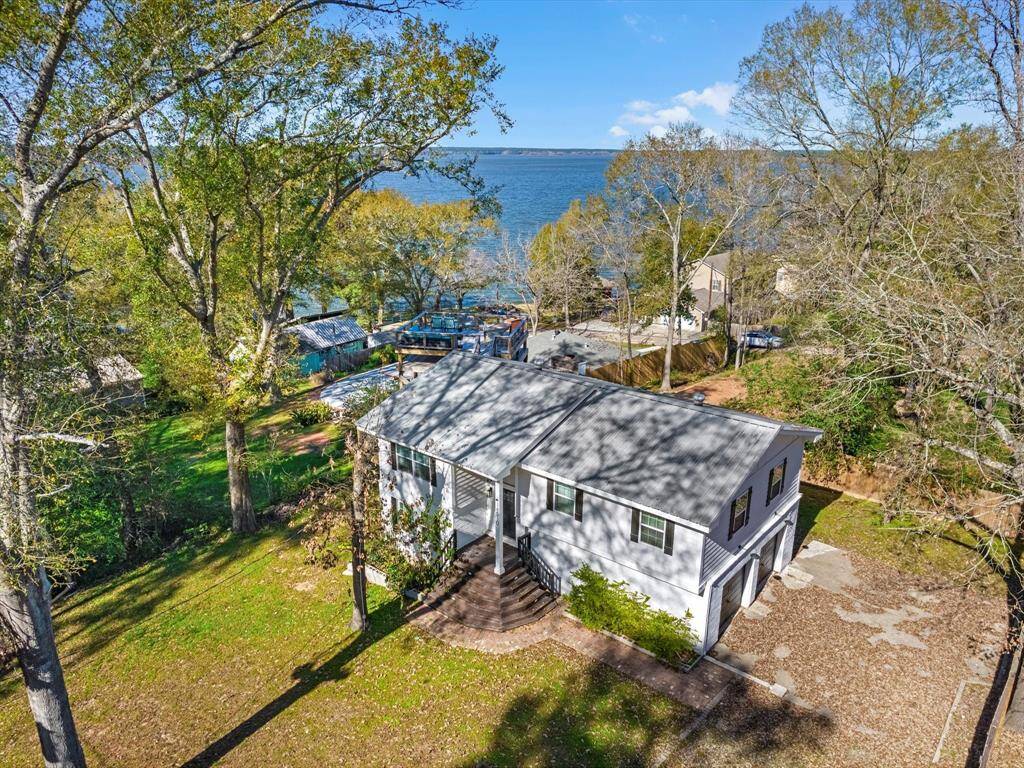 This charming lakeside home offers a serene setting with mature trees and a spacious yard. The property features a cozy, well-maintained house with a metal roof and a scenic view of the water, perfect for nature lovers seeking a peaceful retreat.