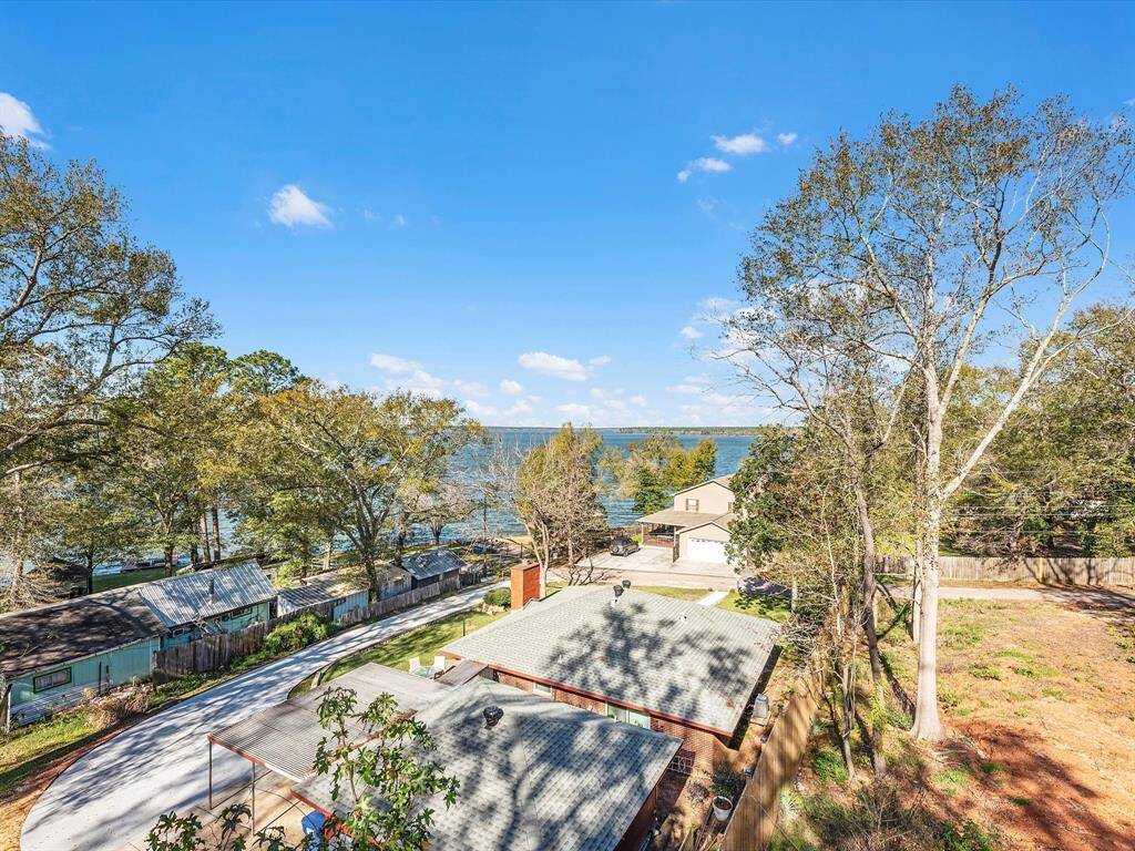 A beautiful property with a scenic view of a large lake, surrounded by mature trees. The home appears to be in a quiet, natural setting, ideal for those seeking a peaceful lakeside lifestyle.