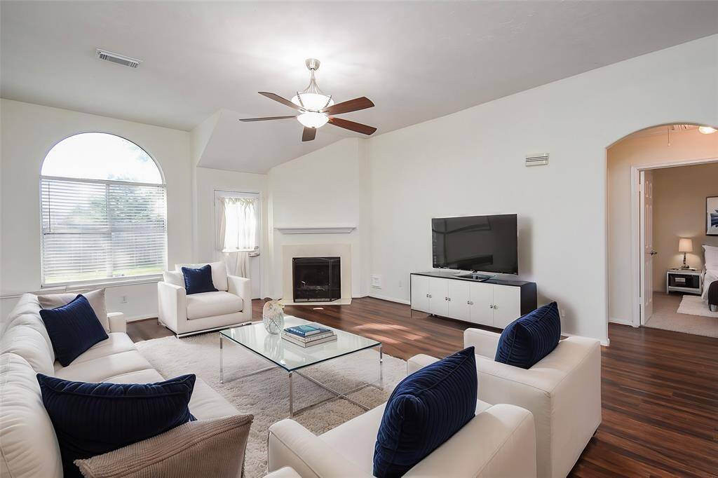 The expansive arched window dominates the room, flooding it with natural light, creating an inviting atmosphere, and showcasing stunning outdoor views.