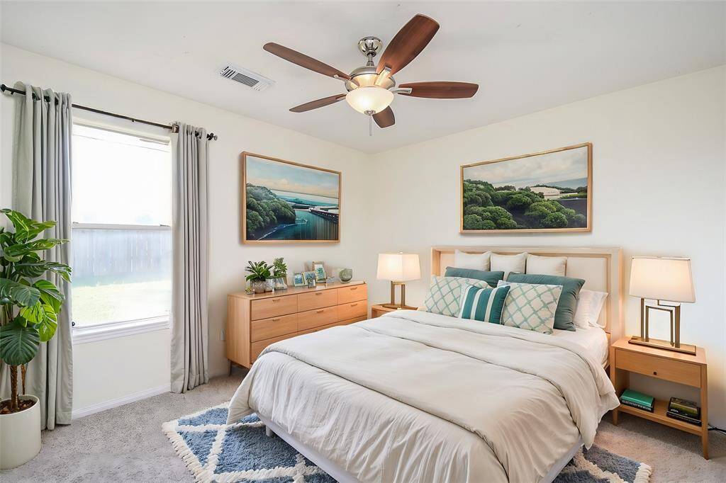 A large window floods the room with sunlight, creating a bright and cheerful atmosphere throughout the day. The plush carpet beneath provides warmth and comfort, making it ideal for relaxing after a long day.