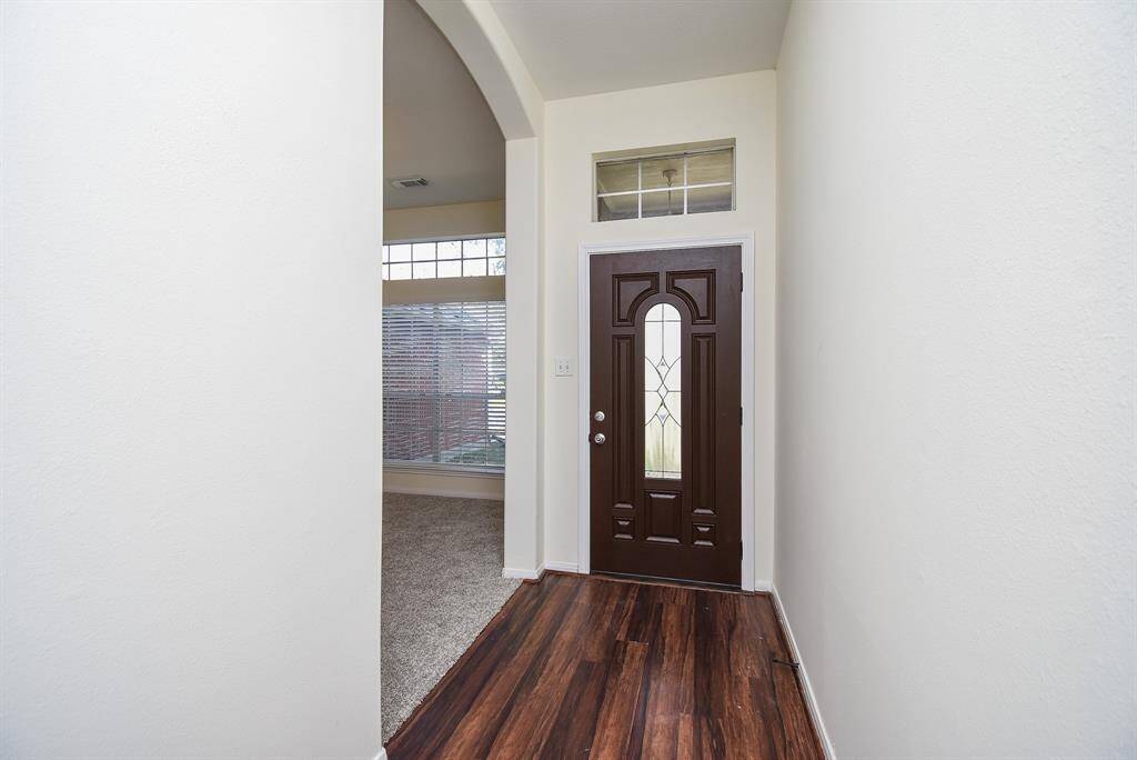 A striking dark wood door featuring intricate glass detailing that commands attention and elevates curb appeal.