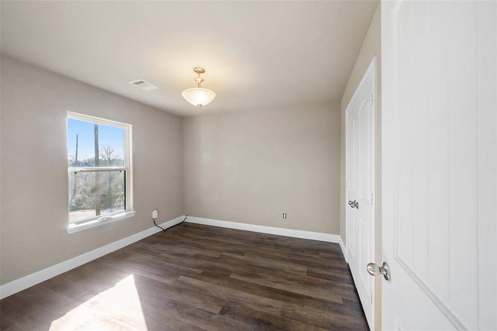 Another beautiful bedroom with wood flooring and a large closet!