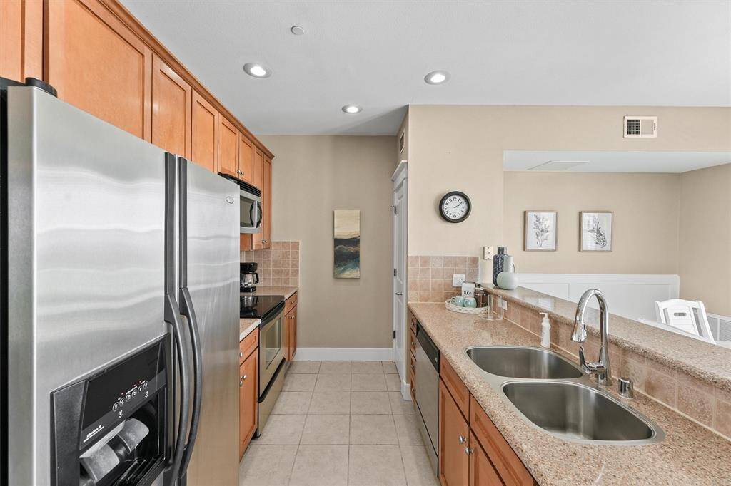 Recessed lighting and a well-planned layout enhance the kitchen's efficiency and ambiance. The pass-through counter to the dining area makes serving meals convenient and enjoyable.
