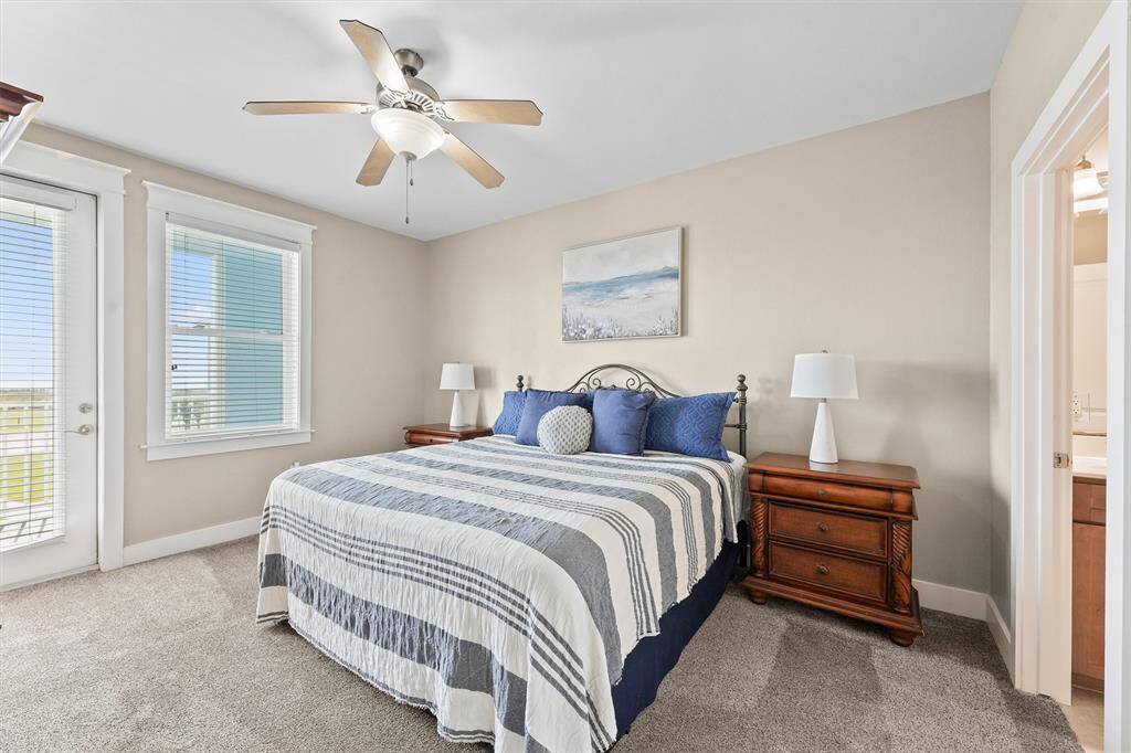 This primary bedroom offers abundant natural light through large windows and a private entrance to the balcony. The space is designed for relaxation with a serene and inviting atmosphere.