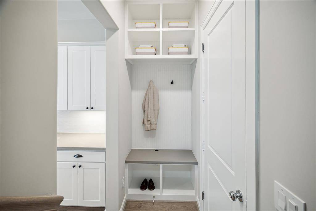 Mud area featuring built-in shelves and a bench. (virtually staged)