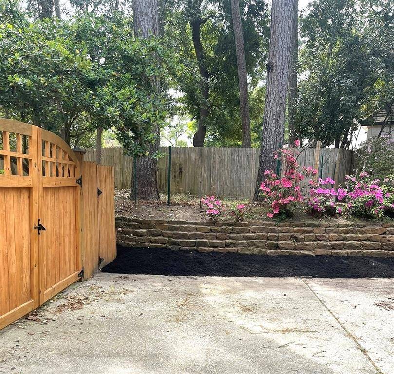 Charming wooden gate opens to a serene backyard retreat.
