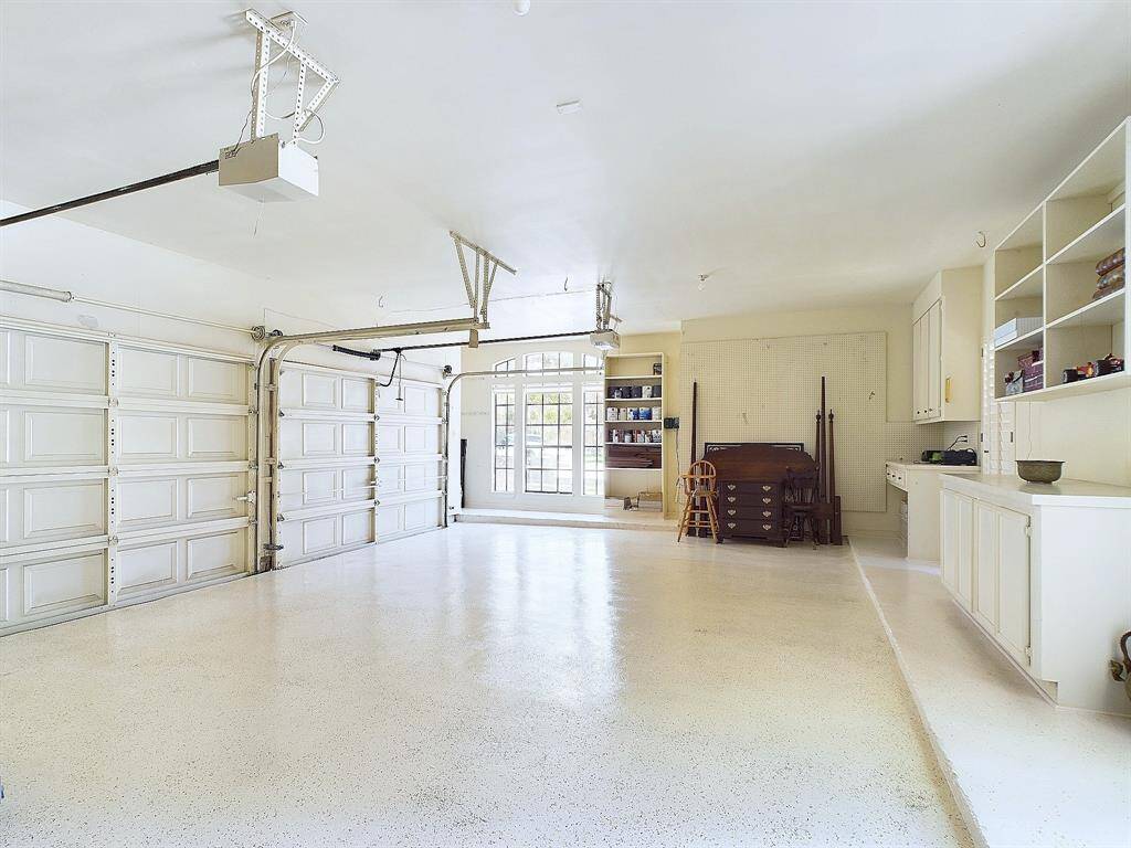 Spacious 3-car garage featuring sleek, newly coated epoxy floors.