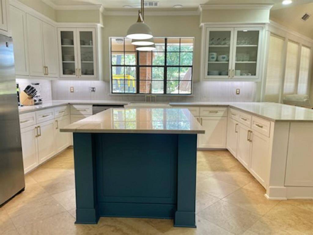 Modern kitchen with custom cabinets, quartzite countertops, and fresh paint.