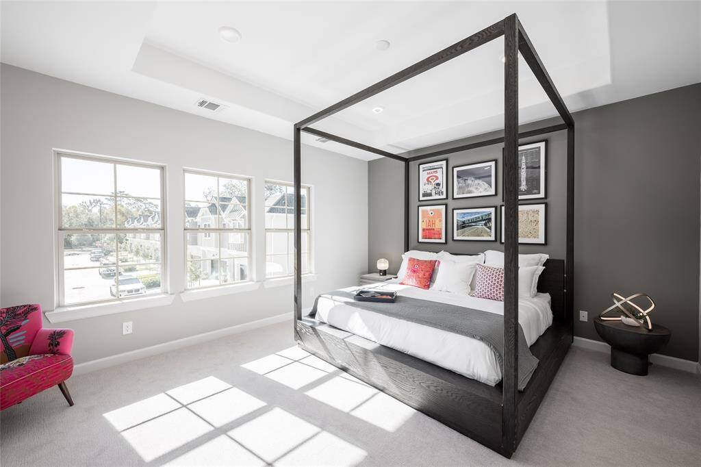 Gorgeous primary bedroom has raised ceiling and many windows to bring in natural lights.