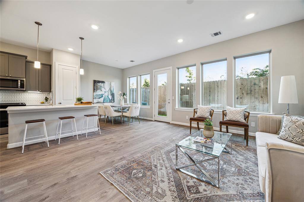 Living room overlooking private back yards has many windows and French door bringing in natural lights.