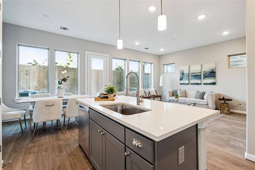 Kitchen open to the living and dining space with quartz seating island, and expansive quartz countertops.