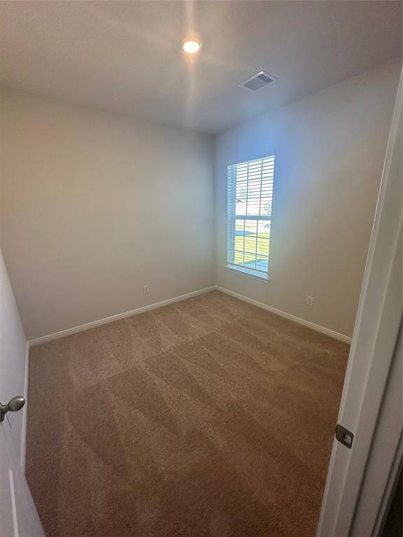 This secondary bedroom is bright and inviting, featuring a large window that allows natural light to flood the space.