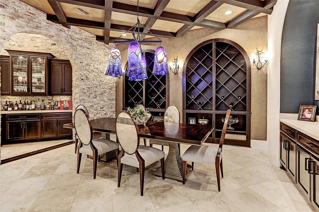 Formal Dining | Stacked stone walls adorn this gorgeous formal dining with custom built-in wine racks and a serving bar convenient for hosting dinner parties with friends and family